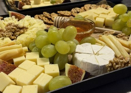 Käseplatte (4 Käsesorten) mit weißen Trauben, Walnüssen und Honig